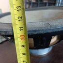 Fotografie detailu černého reproduktoru s naměřeným průměrem pomocí žlutéhov metrů. Viditelný je okraj membrány s viditelnou prasklinou v materiálu.…