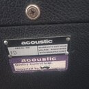 Detailní záběr na zadní část černého přístroje potaženého texturou imitující kůži. Na povrchu jsou dvě nálepky značky acoustic; horní obsahuje text S…