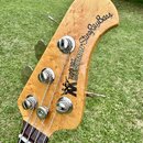 Hlava basové kytary z vyvrtaného světlého dřeva s viditnou strukturou. Na povrchu je černý nápis ERNIE BALL MUSICMAN StingRayBass a doprovodné logo s…