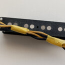 Černý elektrický snímač s šesti viditelnými bílými póly. Na pravém okrape je vyrytý nápis Seymour Duncan. Ze snímače vedou černé a žluté vodiče, kter…