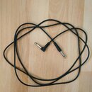 Černý instrumentální kabel s konektory typu jack. Jeden konektor je rovný a druhý pravý. Na kabelu nejsou viditelné žádné značky ani nápisy.