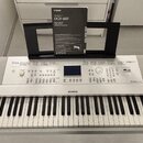 Bílá digitální klaviatura značky YAMAHA, model DGX-660. Nástroj má v horní části ovládací panel s displejem, tlačítky a knoflíky, vpravo je nápis Dig…