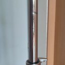 Detail stříbrného kovového stativu s teleskopickým mechanismem. Na spodní části je viditelný modrý proužek s bílým nápisem YAMAHA a menším textem MAD…