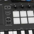 Detailní pohled na ovládací panel černého MIDI kontroléru. Jsou vidět posuvníky s nápisy Pitch a Modulation, pět otočných potenciometrů a mřížka bílý…