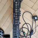 Fotografie zachycuje zadní panel černého elektronického zařízení značky BOSS. Jsou zde viditelné různé vstupy a výstupy s nápisy jako MIC, PHANTOM, L…