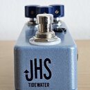 Modrý efekt pedál s kovovým povrchem a stříbrným spínacím tlačítkem. Na přední straně je černý nápis JHS a pod ním TIDEWATER. V horní části jsou vidě…
