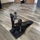 Černý basový pedál s kovovou konstrukcí a řetězovým přenosem. Na bočním rameni je svisle napsán bílý nápis MAPEX. Beater má černou základnu s bílým l…