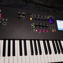 Černý digitální klavír značky YAMAHA. Horní panel obsahuje ovládací prvky, knoflíky a displej s nápisem CPX + FM EP 2. Klávesnice má standardní bílé…