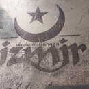 Detailní záběr na kovový povrch s vyrytým nebo vytištěným logem. V horní části je symbol půlměsíce a hvězdy, pod ním je nápis made in Canada a výrazn…