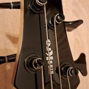 Detail hlavy černé elektrické basy s nápisy GIO Ibanez SOUNDGEAR a svislým nápisem mikro. Na hlave jsou vidět čtyři ladicí mechanismy s našroubovaným…
