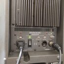 Zadní panel šedého reproduktoru značky MACKIE, model SRM450 s nápisem ACTIVE SOUND REINFORCEMENT MONITOR SYSTEM. Jsou zde vidět přepínače TIMED TURNO…