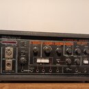 Černý efektový procesor Roland CHORUS ECHO RE-501 v robustním pouzdře. Přední panel obsahuje různé ovládací knofíky, přepínače a vstupní/výstupní kon…
