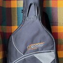 Černý polstvuovaný obal na kytaru s šedými lemovacími pruhy. Na přední straně je oranžovo-bílé logo CANTO MUSIC EQUIPMENT a v dolní části bílý nápis…