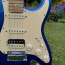 Modrá elektrická kytara s krémovým pickguardem a hnedým hmatníkem. Na snímačích jsou nápisy NOISELESS a na prostředním snímači je viditelné logo Fend…