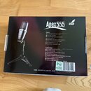 Fotografie znázorňuje kartonové balení USB mikrofonu. Na krabici je nápis Apex555 USB a webová adresa www.apexelectronics.com. V levé části je obráze…