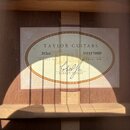 Detailní pohled do vnitřku akustické kytary na štítek s informacemi. Na štítku je uveden nápis TAYLOR GUITARS, model 312ce a SERIAL NO. 11111171029.…