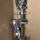 Chromovaná kovová stojanová konstrukce, pravděpodobně část bubeníckého hardware. Na horní části jsou dvě černé plastové držáky. Povrch je lesklý, s v…