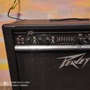 Černý kytarový kombo zesilovač značky Peavey. Horní ovládací panel obsahuje nápisy INPUTS, SHELVING, MASTER VOLUME a modelové označení X-OVER FREQ. N…