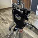 Detailní pohled na horní část chromovaného stojanu s černým plastovým nebo kovovým uzamykacím mechanismem. Na spodní části chromované trubice je vidi…