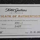 Fotografie znázorňuje certifikát pravosti (CERTIFICATE OF AUTHENTICITY) od značky Xotic Guitars CALIFORNIA. Dokument obsahuje ručně dopsaný model XTC…