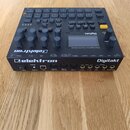 Černý digitální sampler a drum machine značky Elektron, model Digitakt. Na horním panelu je displej, několik řad tlačítek a otočných ovladačů; v prav…