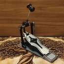 Jednoduchý basový pedál v černo-stříbrném provedení s kovovými komponenty. Na horní části mechanismu je viditelný nápis "TAMA". Povrch pedálu vykazuj…