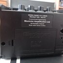 Zadní strana černého kompaktního zesilovače s plastovým povrchem. Na černé štítku je bílý text: MODEL NAME: FLY 3 BASS, PRODUCT NO.: 102114, Designed…