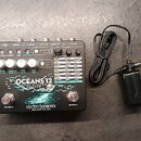 Stříbrný efekt pedál s nápisy OCEANS 12, DUAL STEREO REVERB a značkou electro-harmonix NEW YORK CITY, USA. Horní panel obsahuje pět bílých otočných o…