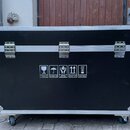 Černý transportní flightcase s hliníkovými hranami a kovovými rohy. Přední strana obsahuje tři stříbrné zapínací zámky a bílé informační piktogramy s…
