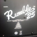 Detail zadní strany černého komba s bílými nápisy. Uprostřed je velký stylizovaný nápis Rumble 25 a nad ním slovo MODEL. Pod tím je text A PRODUCT OF…