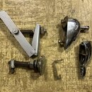 Sada kovových náhradních dílů pro hudební nástroj v stříbrné barvě. Soubor obsahuje mechanismus s pružinou, dvě chromované krytky a šroub s pružinou…