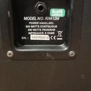 Detail zadní strany kytarového reproduktorového boxu s černým povrchem. Na černé štítku je bílý nápis Randall® a text MODEL NO. RX412M, POWER HANDLIN…