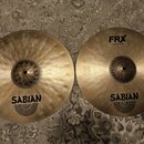 Dvě mosazné činely značky SABIAN. Levý činel má povrch s viditelným kováním a nápis SABIAN s logem. Pravý činely je hladký, nese nápisy FRX, Hats 14"…