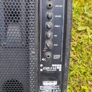 Detailní pohled na ovládací panel černého reproduktoru. Na panelu jsou vstupy MIC a LINE IN, výstup LINE LINK a čtyři otočné ovladače s popisky VOLUM…