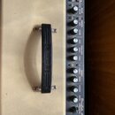 Detailní pohled na ovládací panel kytarového komba v béžovém vinylu s černou plastovou rukojetí. Na ovládacím panelu je nápis Roland a model BoxLayou…