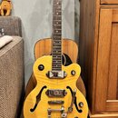 Žlutá polodupatá elektrická kytara s f-otvory a chromovaným hardwarem. Na hlavě je nápis "Epiphone" a na spodní části těla u mostu značka "Epiphone".…