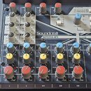 Míchací pult Soundcraft NOTEPAD-8FX s šedým povrchem a modrými detaily. Zařízení obsahuje několik kanálů s ovládacími knoflíky, posuvník Master a sek…