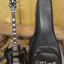 Elektrická kytara s tmavě modrým gradientem a černý polstrovaný obal. Na hlavě kytary je nápis Gibson a označení SG, na obalu je bílý nápis Gibson. K…