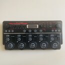 Černý loop station Boss RC-505 Loop Station. Zařízení má pět velkých kulatých pedálů s čísly 1 až 5 a digitální displej v horní části. Na panelu jsou…