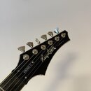 Fotografie zachycuje hlavu elektrické kytary s černým povrchem a bílými nápisy. Na čele je umístěno logo Hagstrom a v dolní části nápis VIKING II. Ná…