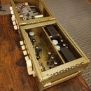 Otevřený elektronický přístroj v kovovém šasi zlaté barvy s texturovaným povrchem. Uvnitř jsou vidět elektronické komponenty, včetně několika vakuový…