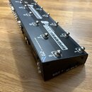 Černý obdélníkový MIDI kontrolér s kovovým povrchem a řadou stomečkových spínačů. Na horní straně jsou vidět nápisy G2, THE ADVANCED SWITCHING SYSTEM…
