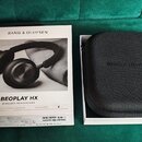 Na fotografii je originální krabice a černý textilní přepravní pouzdro k bezdrátovým sluchátkům. Na krabici je nápis BANG & OLUFSEN a model BEOPLAY H…
