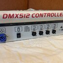 Zadní strana bílého zařízení s červeným nápisem DMX512 CONTROLLER. Na černém panelu jsou umístěny konektory pro napájení AC 100-240V, vypínač POWER a…
