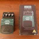 Tmavě zelený efekt pedál s nápisy ULTRA VIBRATO a UV300, doplněný o originální krabici. Na spodní části pedálu je umístěno logo behringer v trojúheln…