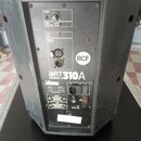 Zadní panel černého aktivního reproduktoru značky RCF. Na panelu je nápis ART 310A SERIES, ovládací prvek VOLUME a přepínač INPUT SENSITIVITY s hodno…