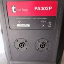 Detail zadní strany černého reproduktoru s červenobílým štítkem. Na štítku je logo „t“, nápis „the box“ a model „PA302P“. Dále je uveden text „Nomina…