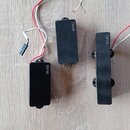 Tři černé elektrické snímače s nápisem EMG. Snímače mají obdélníkový tvar a jsou vybaveny připojovacími kabely v červené a bílé barvě. Povrch snímačů…