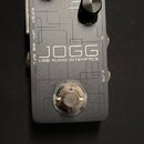 Šedý obdélníkový USB audio interface s kovovým povrchem. Na horní straně jsou dva černé ovládací knoflíky s popisky GAIN a OUTPUT a logo HOTONE. Upro…