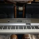 Stříbrný digitální klavír s bílými a černými klávesami. Na horním ovládacím panelu je uprostřed logo YAMAHA a vpravo nápis Clavinova. Nástroj vykazuj…